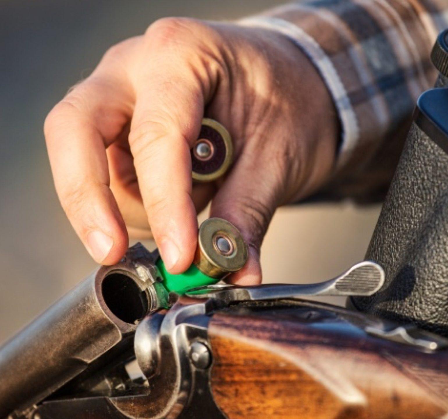 un chasseur charge son fusil de cartouches