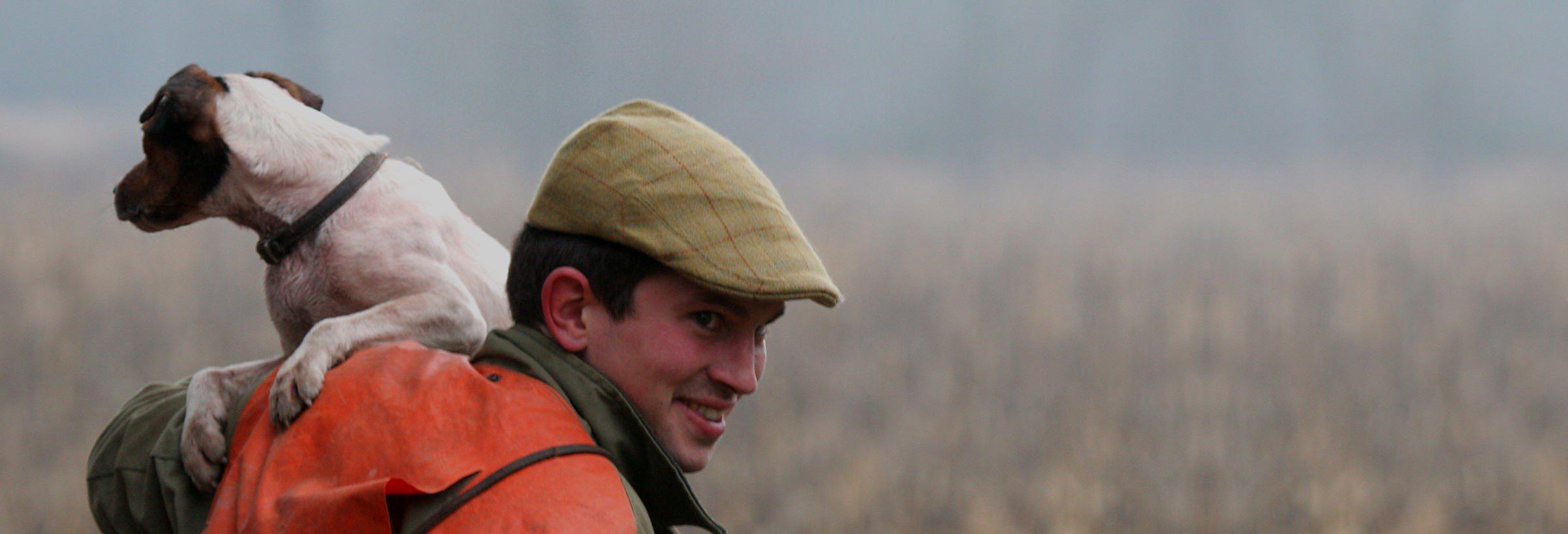 Un chasseur complice avec son chien jack russel sur le dos