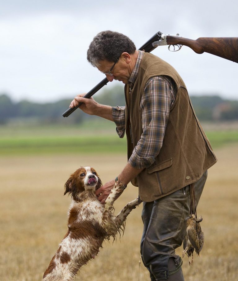 Chasseur avec une arme de chasse et son chien de chasse