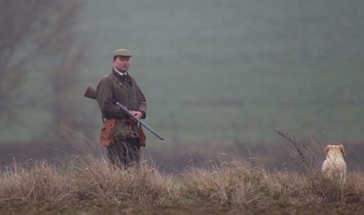 Chasseur de petit gibier devant soi avec son chien de chasse labrador