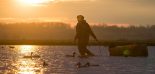 Un chasseur pose des appelants d'oiseaux dans un marais