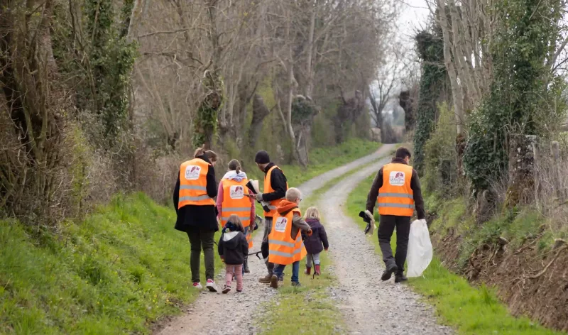 Famille qui ramasse des déchets dans la nature pendant j'aime la nature propre