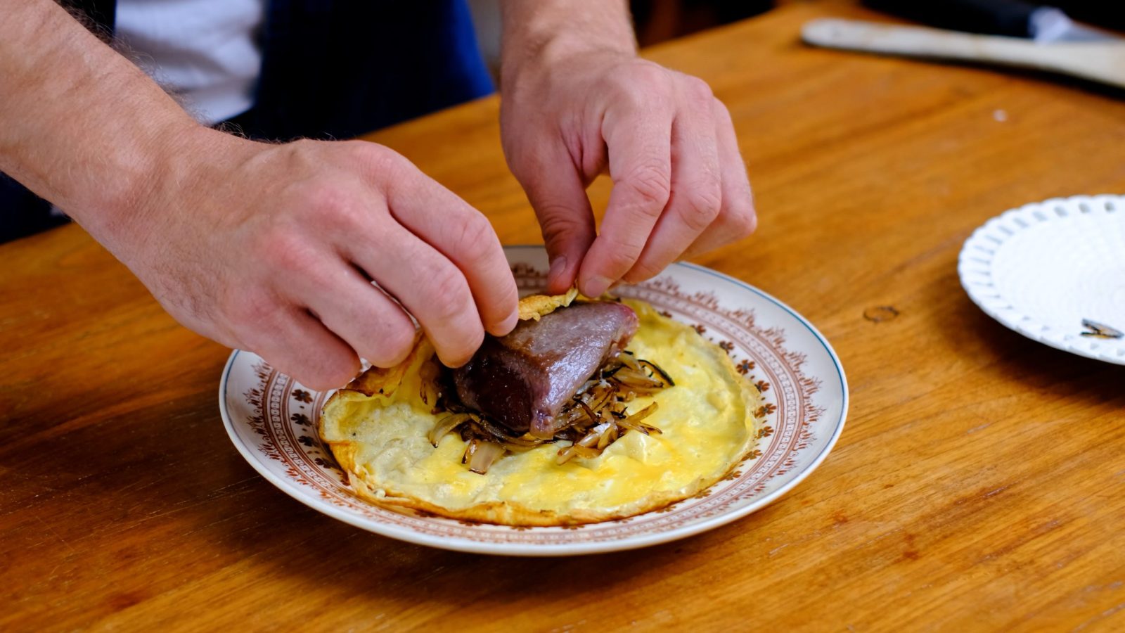 Rôti de chevreuil en train d'être enveloppé dans l'omelette