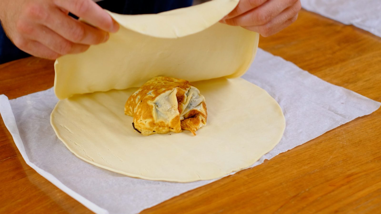 Façonnage de la croute du chevreuil rôti au dessus de l'omelette avec la pâte feuilletée