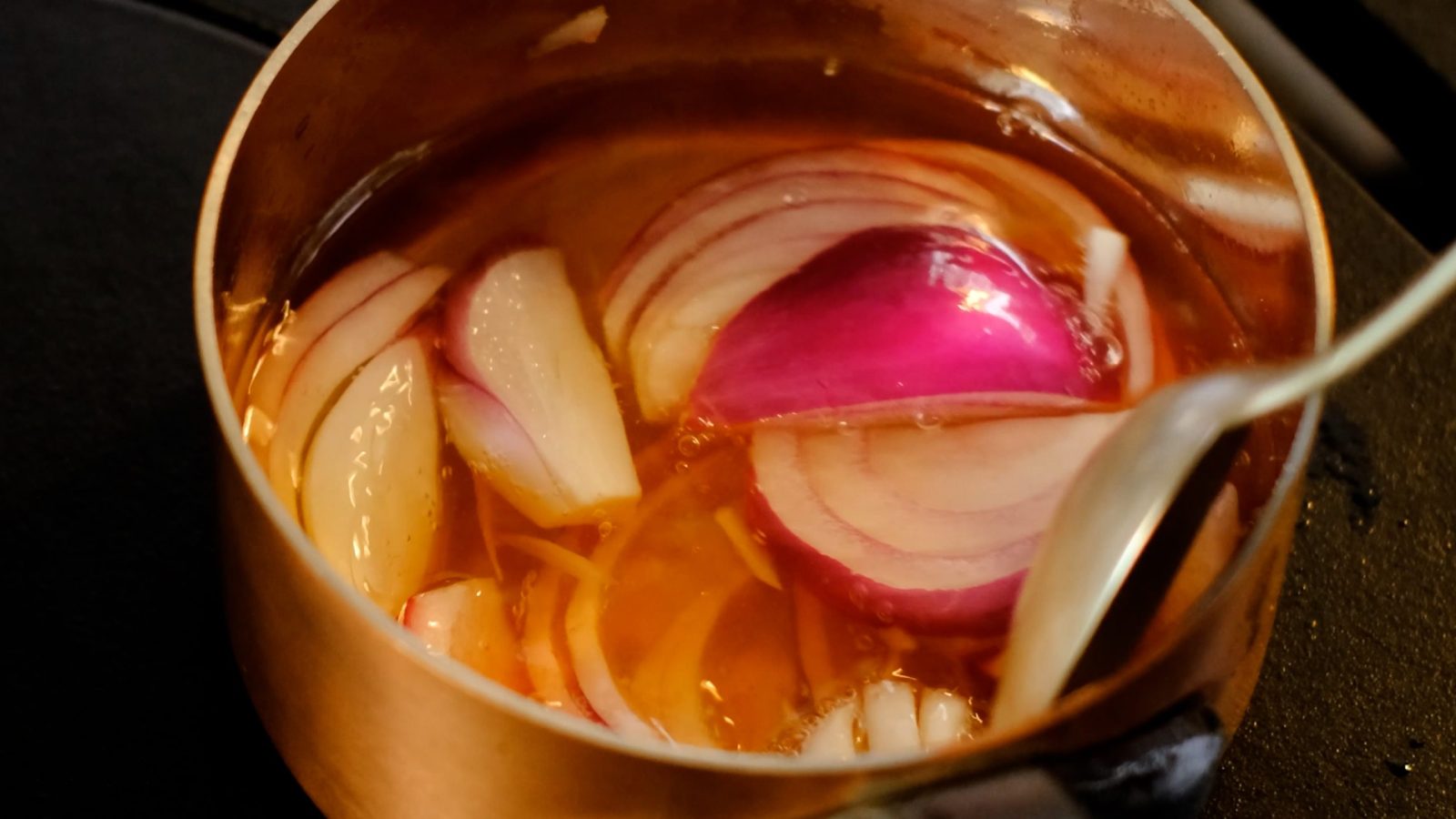 Préparation des pickles d'oignons rouges dans une casserole avec le vinaigre et le sucre