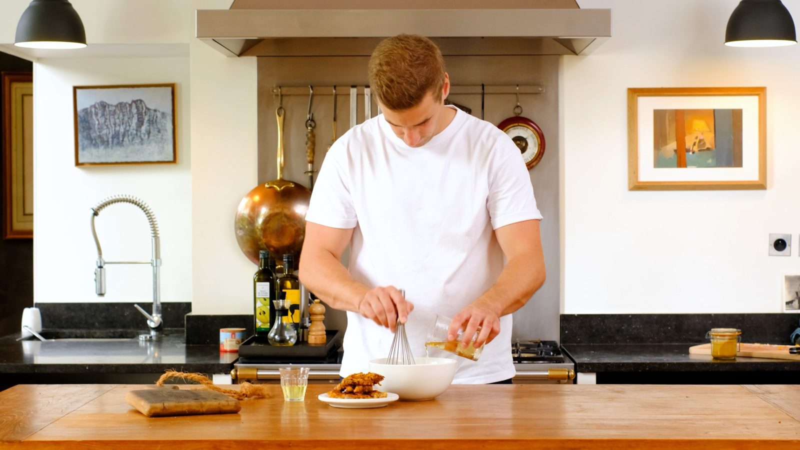 Chef qui prépare de la mayonnaise en ajoutant de l'huile