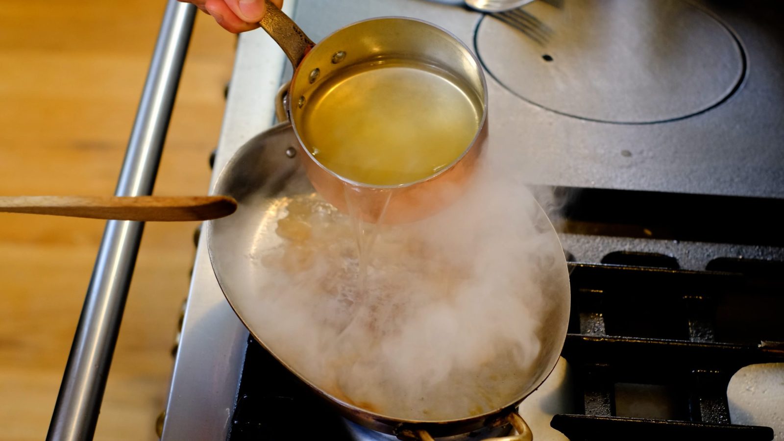 Ajout du vin blanc dans la poêle de cuisson du rôti de cerf