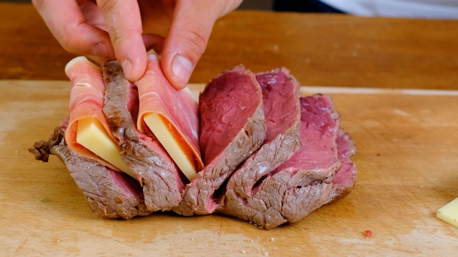 Ajout du fromage et du jambon dans les incisions du rôti de cerf