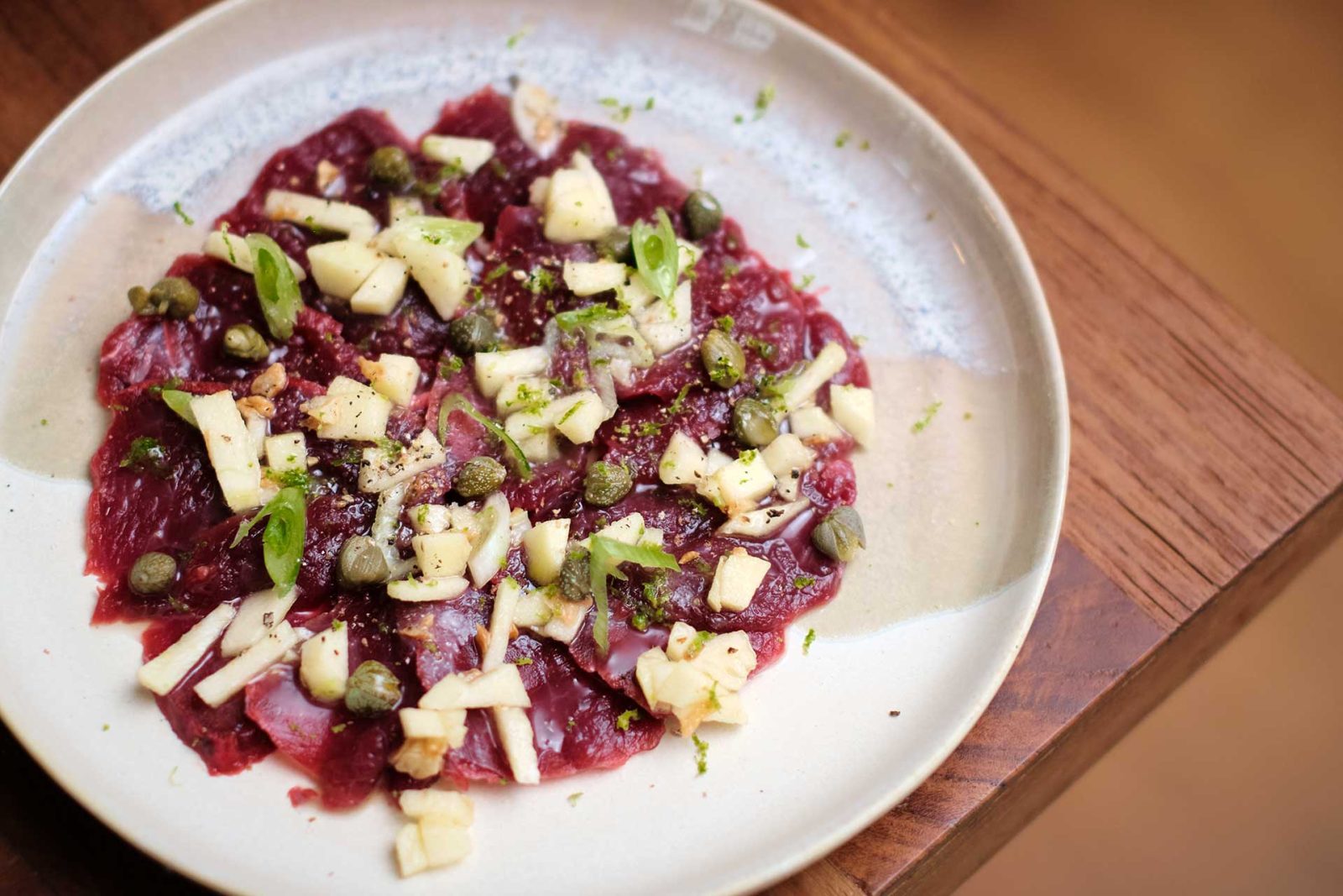 Carpaccio de cerf aux câpres dans une assiette