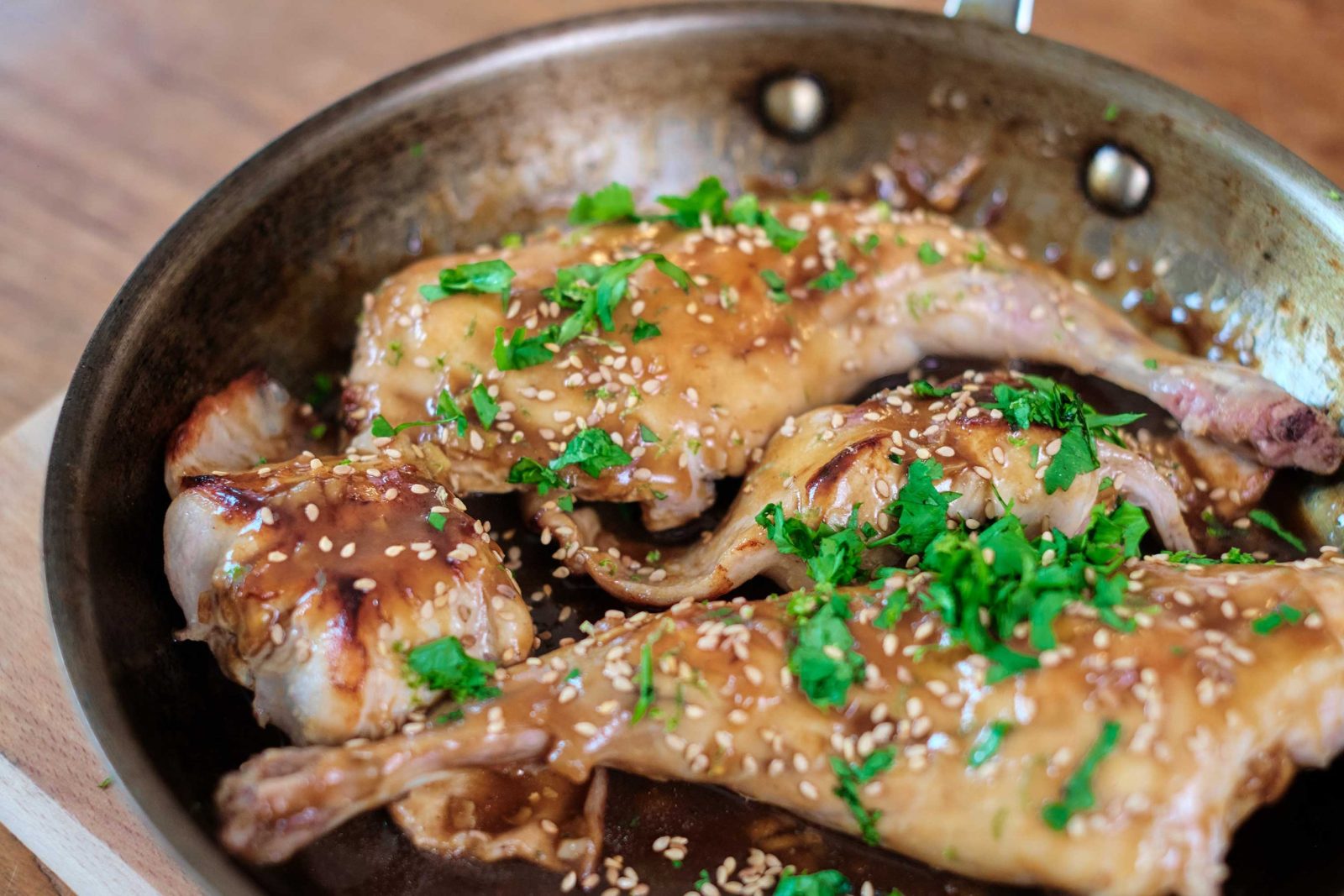Lapin teriyaki dans une poêle avec de la coriandre au dessus